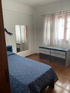 a bedroom with a bed with a blue comforter at Santa Tere in Santa Teresita
