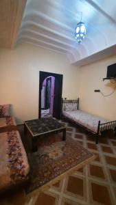 Una sala de estar con un sofá y una mesa de café. en Riad Des Artistes, en Oulad Akkou