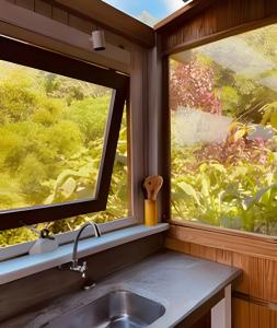 una cucina con un lavandino e una finestra di Casa Fluila a Praia do Rosa