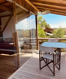 patio con tavolo e sedia sul ponte di Casa Fluila a Praia do Rosa