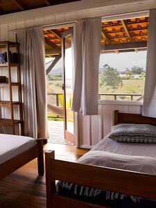 una camera da letto con un letto e una finestra di Casa Fluila a Praia do Rosa Altre 273 foto