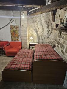 a bedroom with a bed and a red couch at La Casetta nella Roccia in Torricella Peligna +11 photos