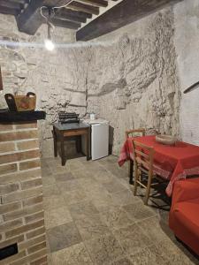 a room with a table and a refrigerator and a table and a table at La Casetta nella Roccia in Torricella Peligna