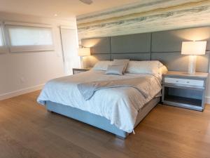 ein Schlafzimmer mit einem großen Bett und zwei Nachttischen in der Unterkunft Bentley Beach House in Sanibel + 49 Fotos