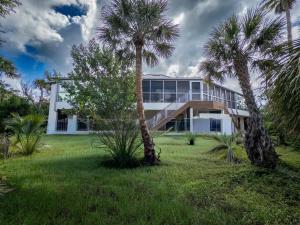 ein weißes Haus mit Palmen davor in der Unterkunft Bentley Beach House in Sanibel