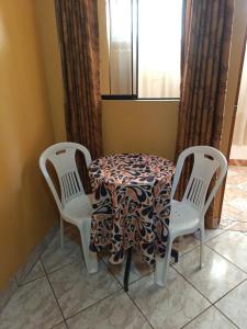 uma mesa com duas cadeiras e uma mesa com uma toalha de mesa em Nasca Trails B&B em Nazca