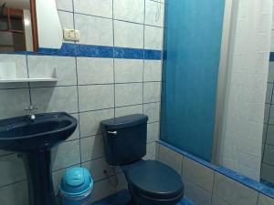 uma casa de banho com um WC azul e um lavatório. em Nasca Trails B&B em Nazca mais 55 fotografias
