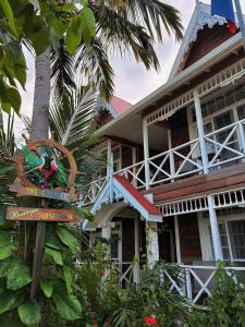 Caye Caulker Boutique Guesthouse 4 في كاي كولكر: منزل أمامه علامة على الشارع