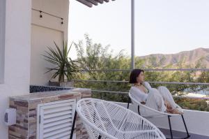 eine Frau auf einem Stuhl auf einem Balkon in der Unterkunft Villa Malibu in Taganga