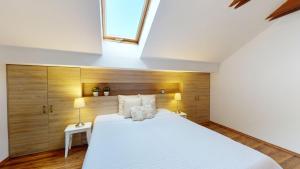 ein Schlafzimmer mit einem weißen Bett und einem Dachfenster in der Unterkunft Hrabovo Helena 19 in Ružomberok