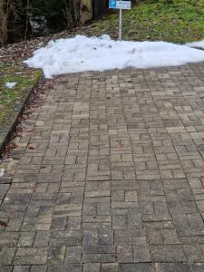 ein Schild auf einem mit Schnee bedeckten Backsteinweg in der Unterkunft Hrabovo Helena 19 in Ružomberok