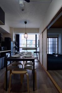 een eetkamer met een tafel en stoelen en een bed bij New Open! Central Kobe 最大9名 三宮,元町,中華街,北野へアクセス抜群 長期宿泊設備充実 in Kobe