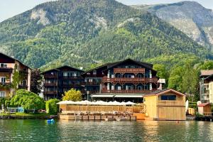 un complejo en el agua frente a una montaña en Strandhotel Margaretha, en St. Wolfgang