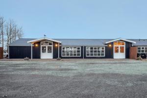 a large black house with white doors and windows at Hestakráin Guesthouse in Selfoss