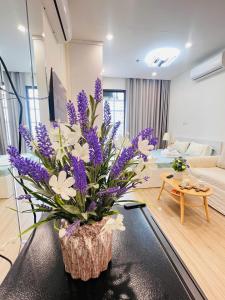 een vaas met paarse bloemen op een tafel in een woonkamer bij Lily House in Kon Rung (1)