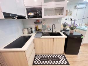 een kleine keuken met een wastafel en een zwarte koelkast bij Lily House in Kon Rung (1) +3 foto's