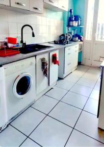 una cocina con lavadora y fregadero en ANGLET, Chambre Privée, QUARTIER CALME, en Anglet
