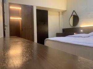 ein Schlafzimmer mit einem Bett und einem Spiegel an der Wand in der Unterkunft Cahaya Residence The Guest House in Kuta