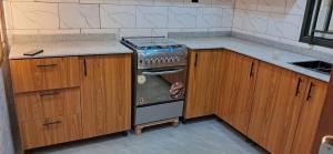 una cucina con piano cottura e armadietti in legno di JAMOS House a Kigali