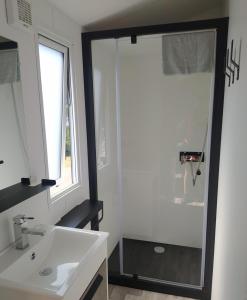 Mobile Homes by KelAir at Camping Sylvamar في لابينيه: حمام مع حوض أبيض ونافذة