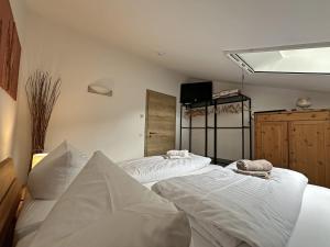 een slaapkamer met twee bedden met witte lakens bij Gschwendtnerhof App25 Schaub in Aschau im Chiemgau