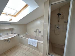 een badkamer met een bad, een wastafel en een douche bij Gschwendtnerhof App25 Schaub in Aschau im Chiemgau +24 foto's