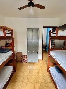 Cosmopolitans Hostel في أوباتوبا: غرفة بها ثلاثة أسرة بطابقين ومروحة سقف