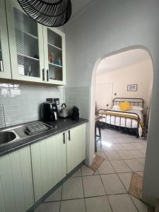 a kitchen with a sink and a bed in a room at Cozy Garden Cottage for Two in Cape Town