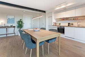 eine Küche und ein Esszimmer mit einem Holztisch und Stühlen in der Unterkunft Gollings am See Gingko-Suite in Bosau