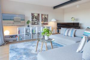 ein Wohnzimmer mit Sofa und Tisch in der Unterkunft Gollings am See Gingko-Suite in Bosau