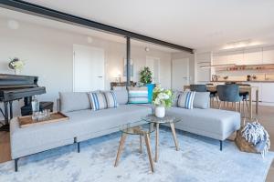 ein Wohnzimmer mit einer Couch und einem Klavier in der Unterkunft Gollings am See Gingko-Suite in Bosau