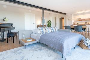 ein Schlafzimmer mit einem großen Bett und einem Klavier in der Unterkunft Gollings am See Gingko-Suite in Bosau