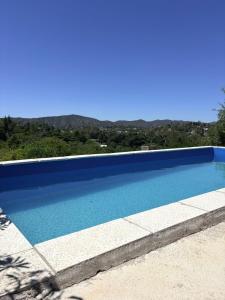 una grande piscina blu con le montagne sullo sfondo di Los Frutales a Villa Carlos Paz Altre 33 foto
