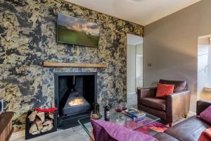 a living room with a couch and a fireplace at Gate Lodge in Castle Douglas