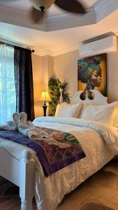 Caye Caulker Boutique Guesthouse 5 في كاي كولكر: غرفة نوم بسرير مع لوحة لامرأة