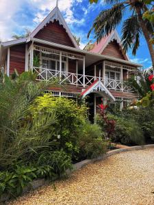 Caye Caulker Boutique Guesthouse 5 في كاي كولكر: منزل أمامه نخلة