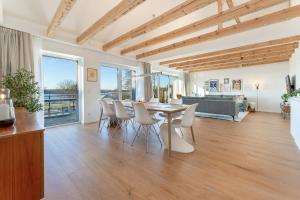 a living room with a table and chairs and a couch at Gollings am See Loft-Suite in Bosau