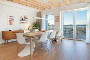 a dining room with a table and white chairs at Gollings am See Loft-Suite in Bosau +20 photos