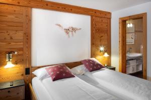 1 dormitorio con cama y lavamanos en Hotel Antika, en Zermatt
