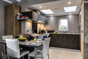 a large kitchen with a table and chairs at Courtyard Cottage in Castle Douglas