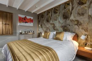 a bedroom with a large bed and a stone wall at Courtyard Cottage in Castle Douglas