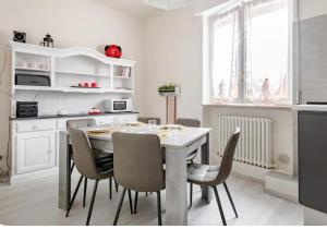 a white kitchen with a table and chairs at Ca`del Fuin in Seregno