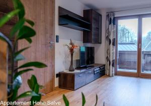 a living room with a television and a vase with flowers at Haus Panorama in Brixen im Thale