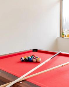 een rode pooltafel met drie speelballen erop bij Ca`del Fuin in Seregno