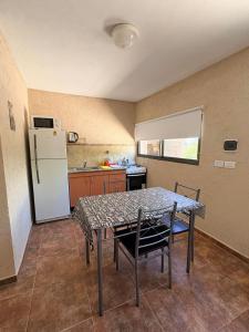 una cucina con tavolo con sedie e frigorifero di Los Frutales a Villa Carlos Paz