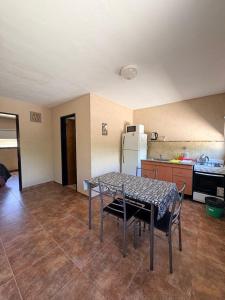 una cucina con tavolo, sedie e frigorifero di Los Frutales a Villa Carlos Paz