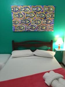 1 dormitorio con 1 cama con una pintura en la pared en Canto do Buganville, en Abraão
