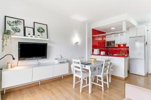 een keuken met witte kasten en een tafel met stoelen bij Francysara Holiday in Benalmádena