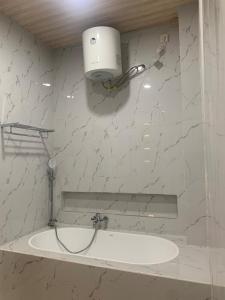 ein Badezimmer mit einem Waschbecken und einem Licht an der Wand in der Unterkunft Cahaya Residence The Guest House in Kuta