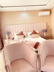 a bedroom with a large bed with two chairs at GEORGE B BOUTIQUE LODGE in Tzaneen